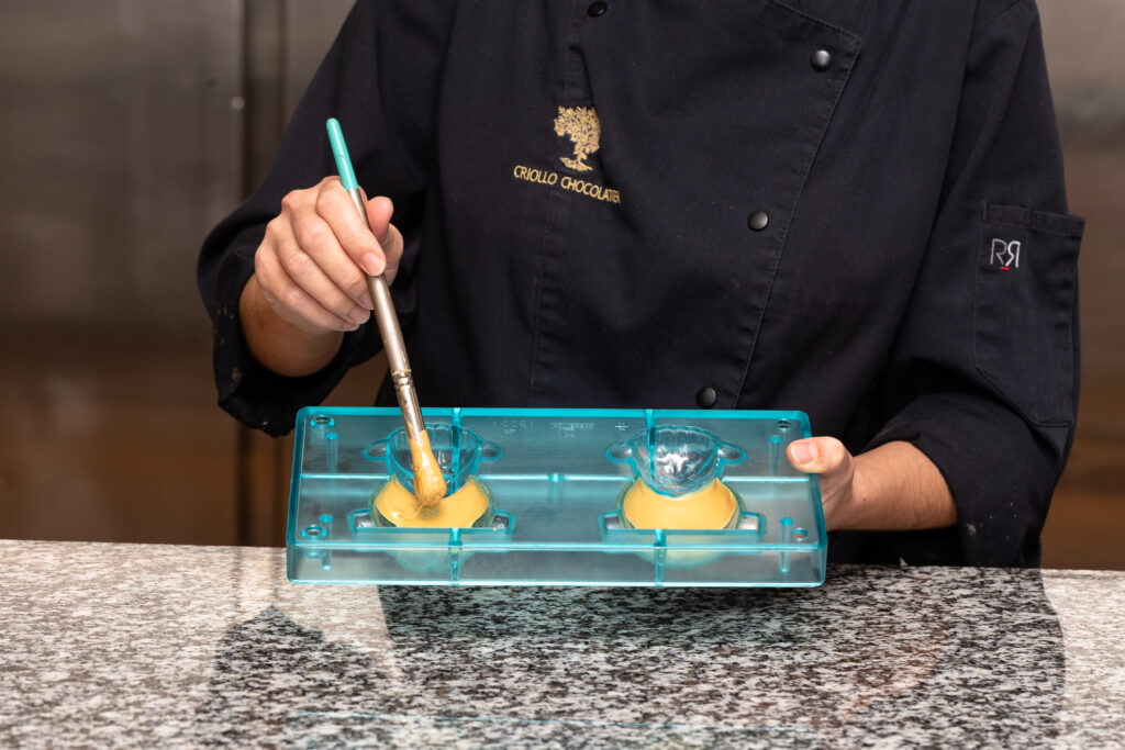 Décor au pinceau, en chocolat blond, d'un moulage de Pâques 